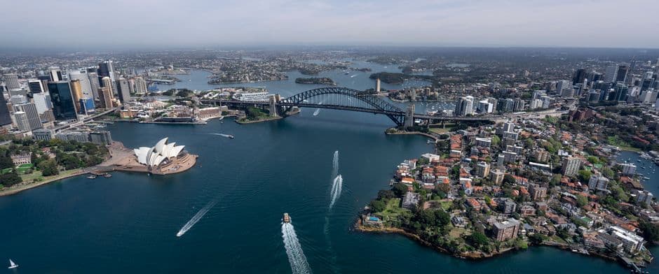 Aerial view of an Australian harbour skyline with blue water.