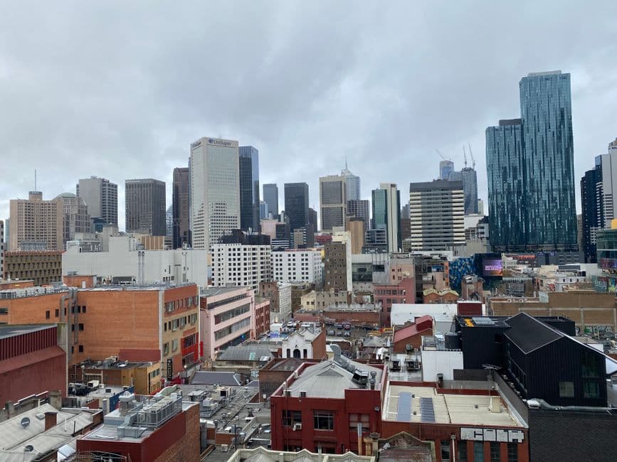 Modern Australian city skyline with skyscrapers and riverfront buildings.