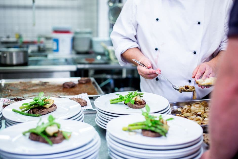 Fine dining restaurant kitchen with chef preparing gourmet dishes.