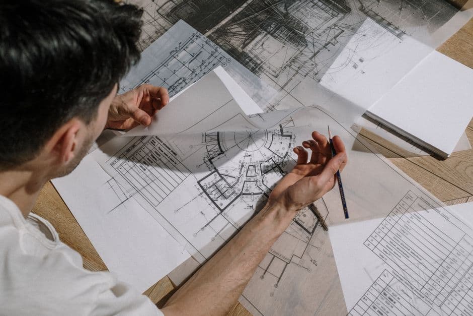 Architects reviewing building plans and blueprints in office.